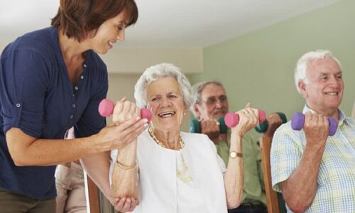 Physiotherapist helping patients to lift weights
